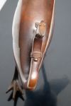 A stylised bronze phoenix-bird on a black lacquered plinth in a box