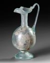 A ROMAN PALE GREEN GLASS EWER, CIRCA 1ST–3RD CENTURY A.D.