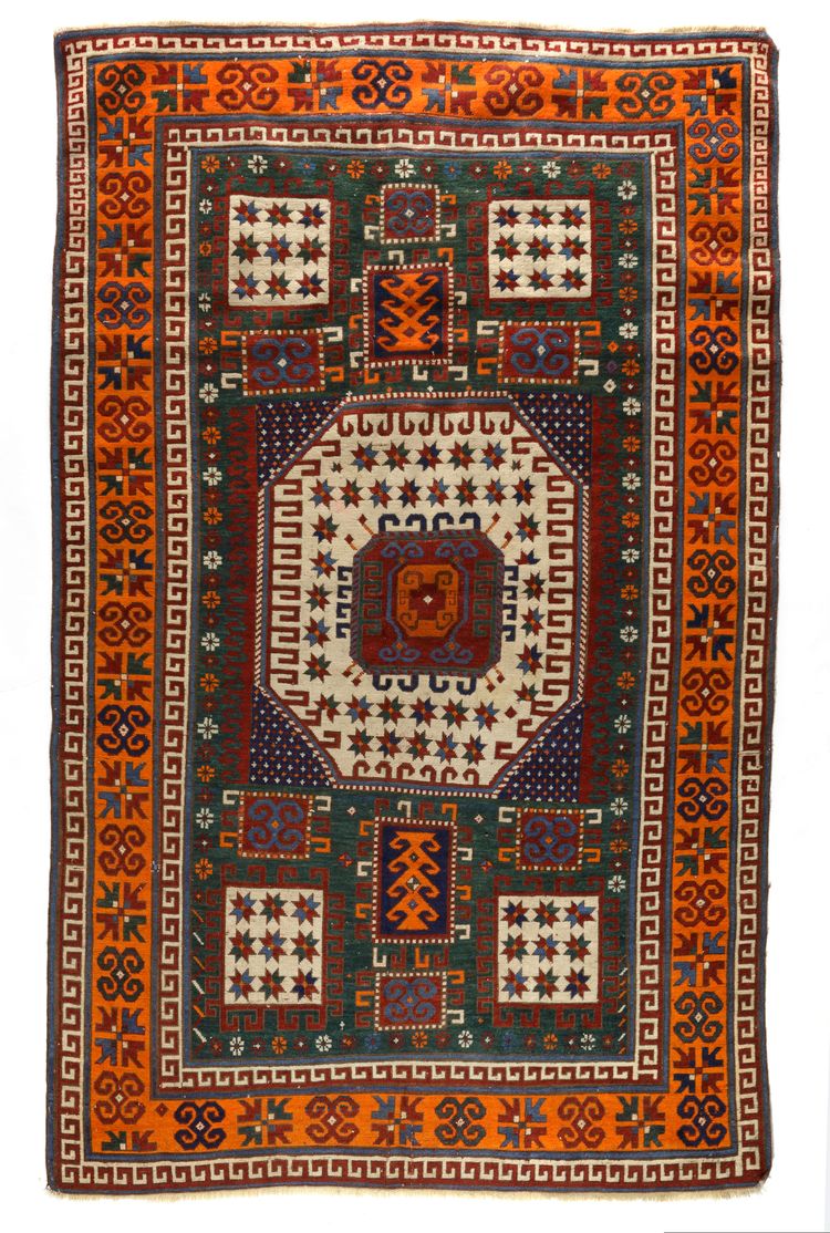 A KARACHOF KAZAK RUG WITH GREEN BACKGROUND