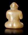 A BEIGE BROWN JADE CROSS LEGGED MALE FIGURE, CHINA, EASTER HAN DYNASTY (25 AD-220 AD)