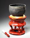 A JAPANESE TEMPLE BELL ON RED LACQUERED STAND WITH PILLOW 