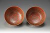 A pair of coral-red and yellow ground bowls with famille rose decoration