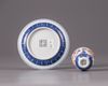 A small Chinese iron-red-decorated blue and white 'dragon' cup and saucer