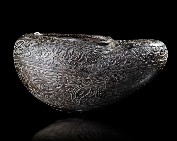 A QAJAR COCO-DE-MER BEGGAR'S BOWL (KASHKUL), PERSIA DATED 1121 AH/1709 AD