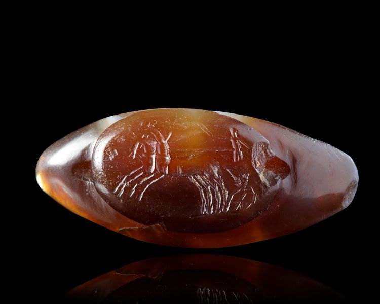 A SARDONYX CARVED BEAD WITH AN INTAGLIO OF A BIGA ADDED IN ROMAN TIMES, 1ST MILLENIUM BC AND 2ND CENTURY AD