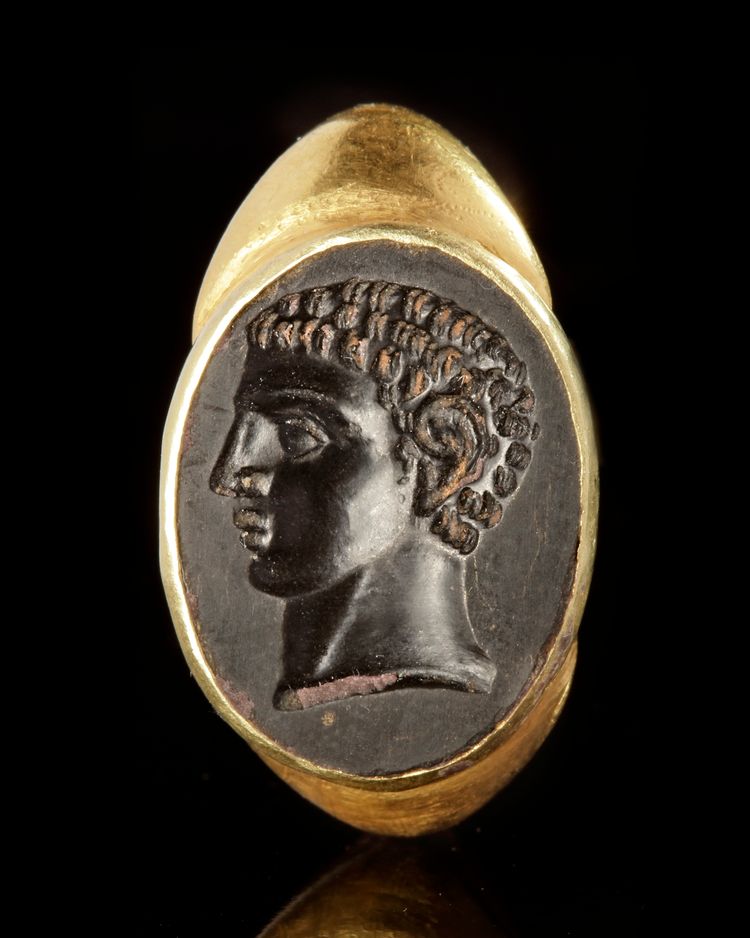A LARGE ROMAN STYLE GOLD RING WITH AN INTAGLIO OF A YOUNG MAN FACING LEFT, 19TH CENTURY AD
