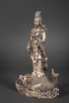 A METAL SCULPTURE OF GUANYIN STANDING ON A FISH, 20TH CENTURY