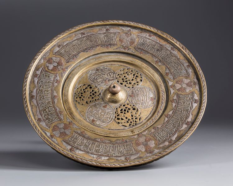 An Islamic silver inlaid brass hand wash bowl