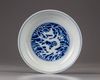 A Chinese blue and white reserve-decorated ‘dragon’ dish