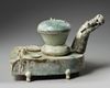 A CHINESE GREEN-GLAZED POTTERY STOVE WITH A DRAGON CHIMNEY