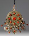 An Islamic gilt and silver inlaid pendant