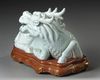 A CHINESE WHITE GLAZED SEATED DRAGON, QING DYNASTY (1644–1911)
