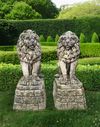 A PAIR OF SCULPTED LIMSTONE MODELS OF LIONS ON PEDESTALS