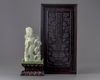 A pale jade carving of a guanyin in a zitan box and stand