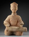 A RARE TERRACOTTA  STATUE OF A SITTING MUSICIAN PLAYING A ZITHER TYPE INSTRUMENT, CHINA, EASTERN HAN DYNASTY (25-220 AD)