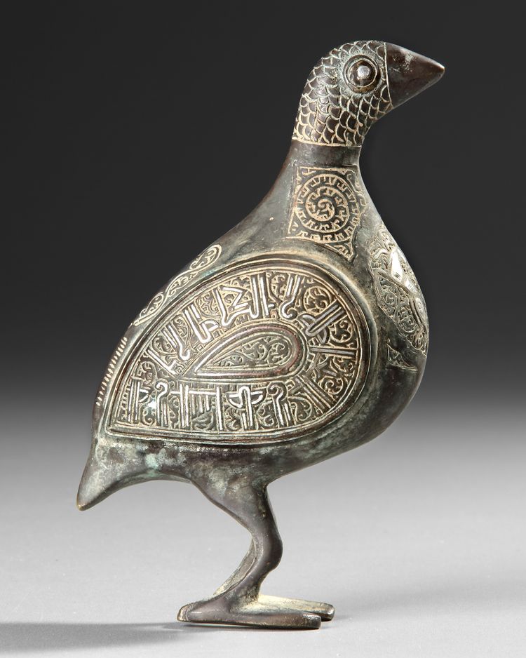 A PERSIAN SILVER INLAID BRONZE BIRD, KHURASSAN STYLE, 19TH-20TH CENTURY