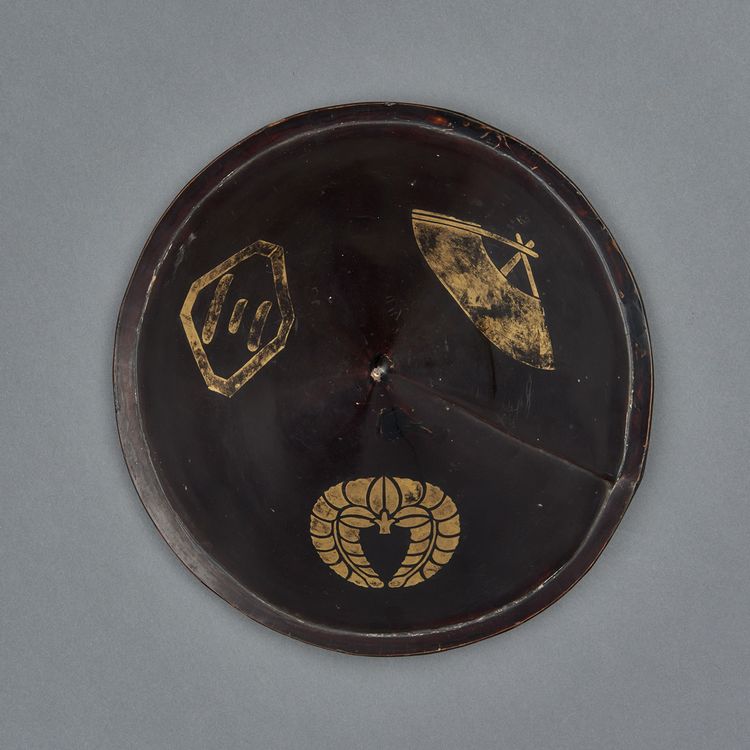 A conical black lacquered samurai hat (jingasa)