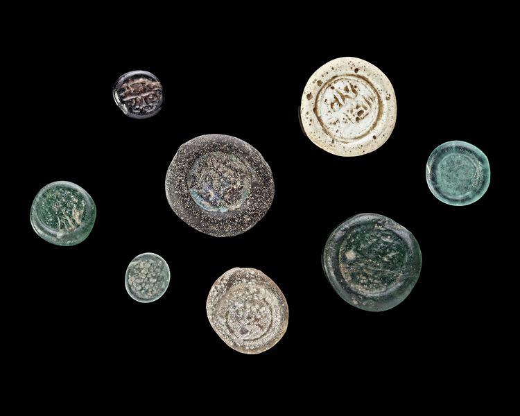 A GROUP OF EIGHT EARLY ISLAMIC GLASS WEIGHTS