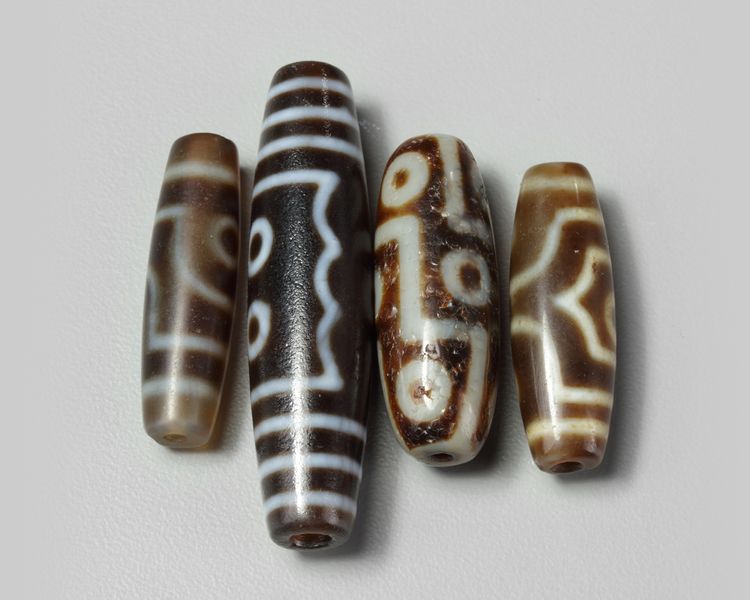 A group of four Tibetan dzi beads