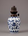 A Chinese blue and white jar with a copper oil lamp cover
