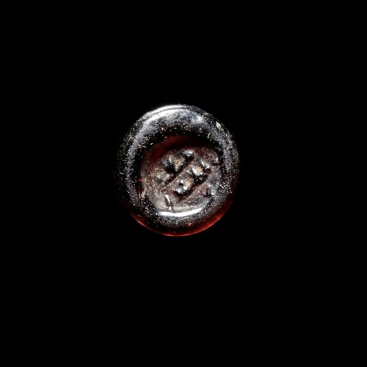 A FATIMID GLASS WEIGHT OF HALF DIRHAM, AL-MUSTANSIR BI-ALLAH (AH 427-487 / 1036-1094 AD)