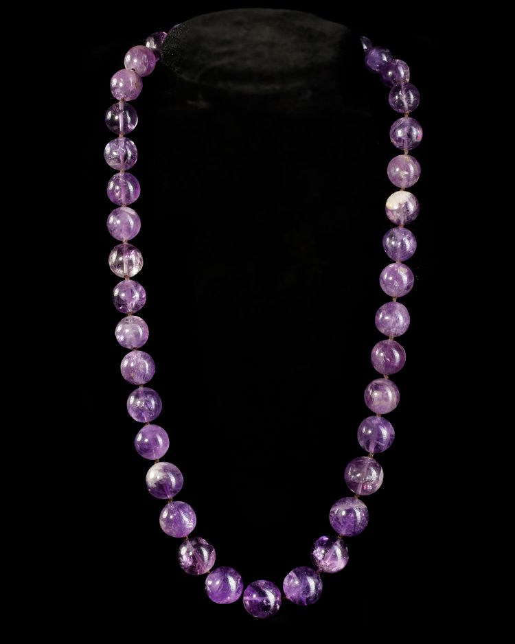 A BEAUTIFUL NECKLACE COMPOSED OF GLOWING PURPLE AMETHYST BEADS,
