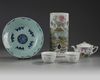 A Chinese famille rose hatstand, a famille rose three-piece tea set, and a celadon-ground blue and white dish