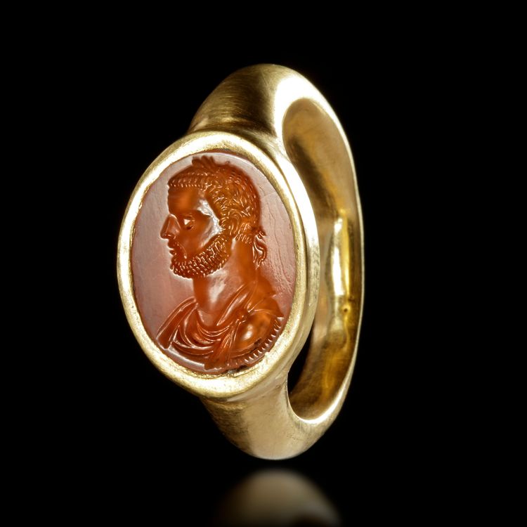 A ROMAN GOLD RING WITH A CARNELIAN INTAGLIO SHOWING THE HEAD OF AN EMPEROR, 4TH CENTURY AD