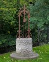 A CONTINENTAL SCULPTED LIMESTONE WELLHEAD AND WROUGHT IRON MOUNTED OVERTRHROW, 20TH CENTURY