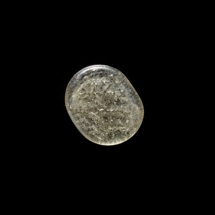 A FATIMID GLASS WEIGHT OF QUARTER DINAR, EGYPT AL-MUSTANSIR BI-ALLAH (AH 427-487 / 1036-1094 AD)