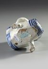 A BLUE AND WHITE BACCHUS ON A WINE BARREL, PROBABLY BRUSSELS 18TH CENTURY