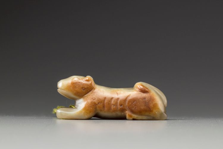 A celadon and russet jade carving of a hound