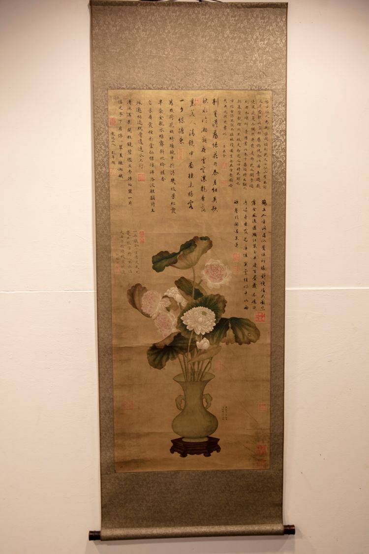 A Chinese hanging scroll depicting a vase with flowers and Chinese calligraphy