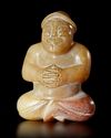 A BEIGE BROWN JADE CROSS LEGGED MALE FIGURE, CHINA, EASTER HAN DYNASTY (25 AD-220 AD)
