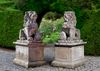 A PAIR OF SCULPTED LIMESTONE MODELS OF LIONS ON PEDESTALS, SECOND HALF 20TH CENTURY