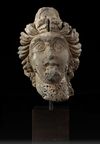A ROMAN BASALT HEAD OF A WOMAN "HAURAN", CIRCA 2ND CENTURY A.D.