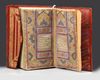 A SMALL RED LEATHER-BOUND QURAN