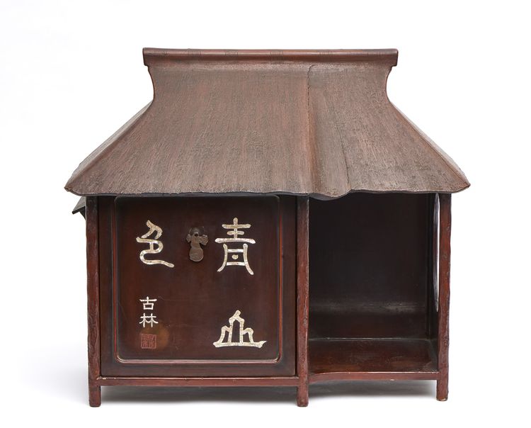 A Japanese wooden stand for tea utensils in the shape of a thatched tea house