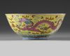A Chinese yellow ground famille rose 'dragon and phoenix' bowl