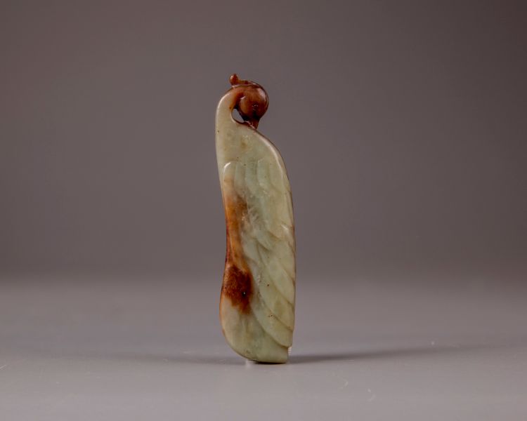 A Chinese celadon and russet jade carving of a peacock