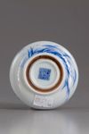 A blue and white circular paste box and cover