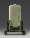 A CHINESE PALE CELADON JADE PLAQUE IN A SPINACH GREEN JADE STAND, 20TH CENTURY