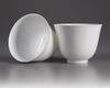 A  PAIR OF SMALL CHINESE WHITE-GLAZED DRAGONS CUPS, 20TH CENTURY