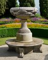 A SCULPTED LIMESTONE CIRUCULAR GARDEN BENCH AROUND AN ORNAMENTAL VASE