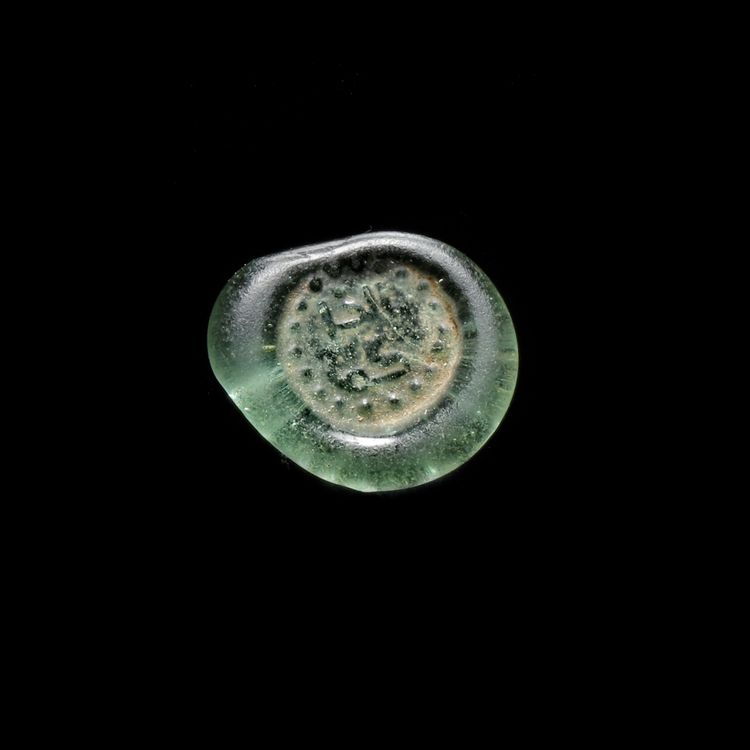 A FATIMID GLASS WEIGHT, AL-HAKIM BI-AMR ALLAH (386AH-411AH/ 996AD-1021AD)
