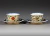 A PAIR OF CAFE AU-LAIT GROUND FAMILLE VERTE CUPS AND SAUCERS, KANGXI PERIOD (1662-1722)