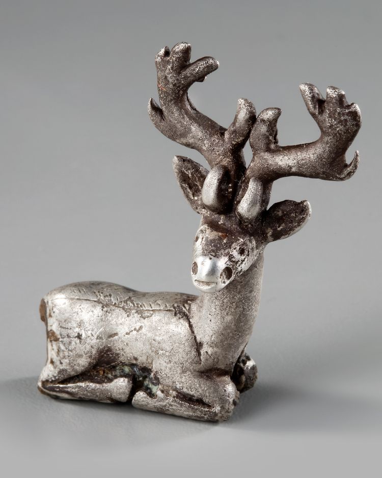 AN ELAMITE SILVER RECLINING STAG, CIRCA 2ND CENTURY B.C.