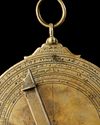 A BRASS ASTROLABE SIGNED BY MUḤAMMAD IBN FATTŪḤ AL-KHAMĀ’IRĪ, SEVILLE (SPAIN), DATED 625 AH / 1227–28 AD