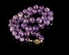 A BEAUTIFUL NECKLACE COMPOSED OF GLOWING PURPLE AMETHYST BEADS,
