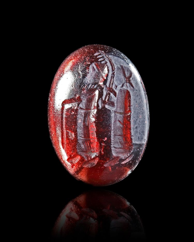 A GARNET CABOUCHON INTAGLIO, WITH TWO STANDING FIGURES, 2ND-3RD CENTURY AD